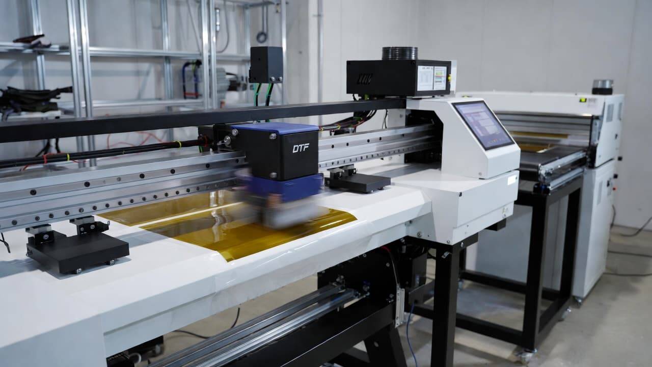 Complete DTF printer setup with powder shaker and dryer in a professional workspace