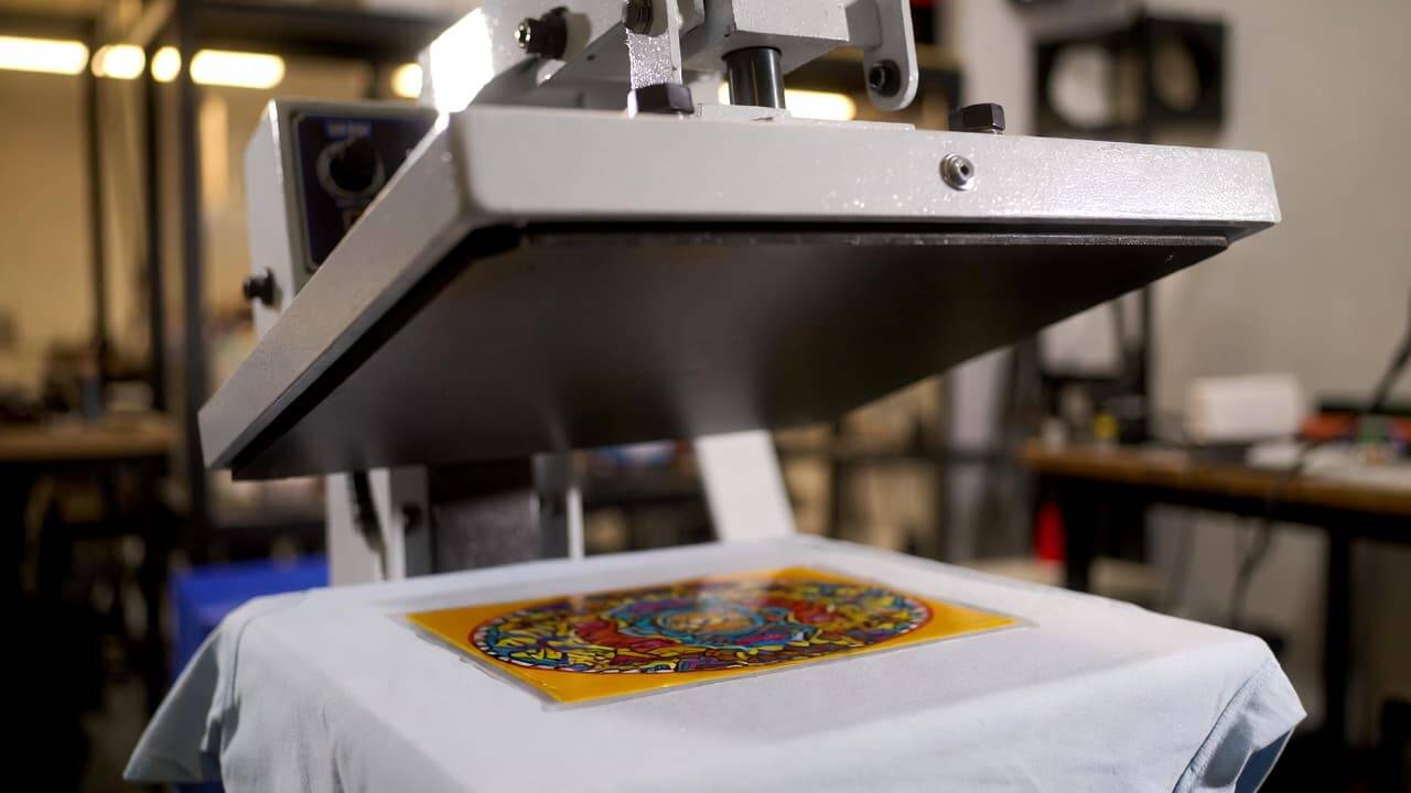 Heat press machine transferring DTF design onto cotton t-shirt